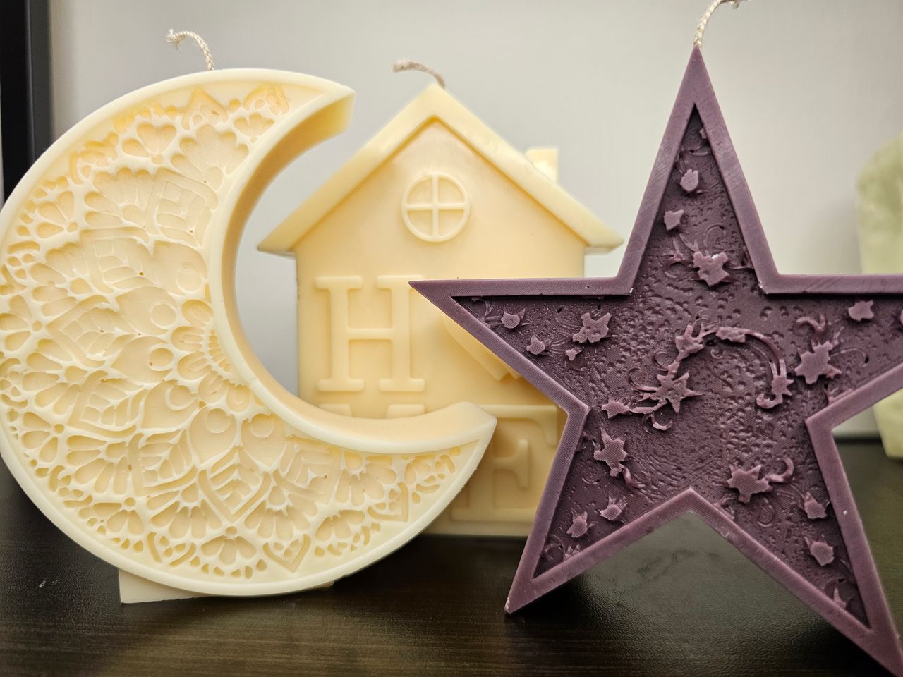 Beautiful decorative moon and star shaped wax candles with intricate designs.